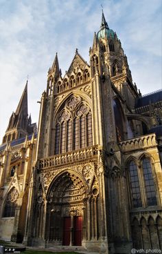 an old cathedral with many spires and windows on the front, against a blue sky