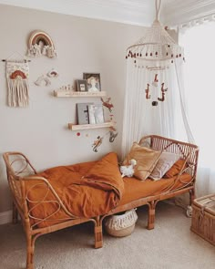 a bedroom with an orange bed in the corner and hanging decorations on the wall above it