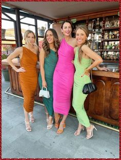 three women standing next to each other in front of a bar