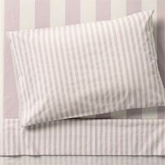 a bed with pink and white striped sheets