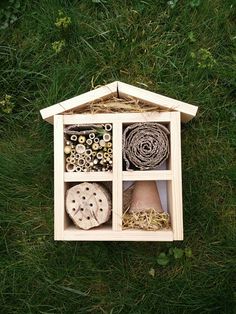 a dollhouse made out of wood with various items in it sitting on the grass