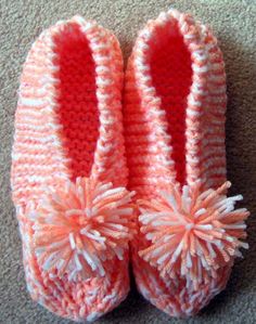 crocheted slippers with pom - poms on the toes and bottom