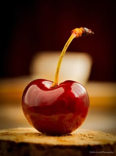 a red apple sitting on top of a wooden table