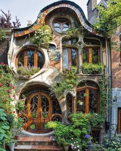 an unusual house with lots of windows and plants growing out of it's sides