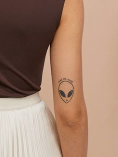 an alien tattoo on the back of a woman's arm