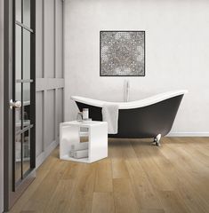 a bath tub sitting next to a wooden floor