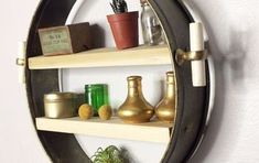 a round mirror sitting on top of a wooden shelf next to a potted plant