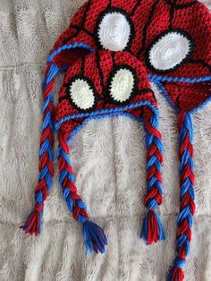 a crocheted spiderman hat laying on top of a bed