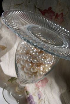 there is a glass bowl with pearls in it