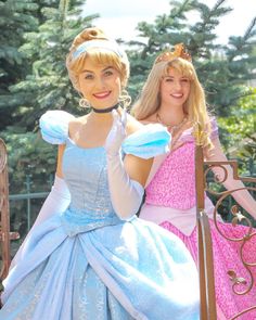 two women dressed as princesses posing for the camera