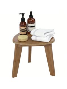 a wooden table topped with two bottles of soap and a brush on top of it