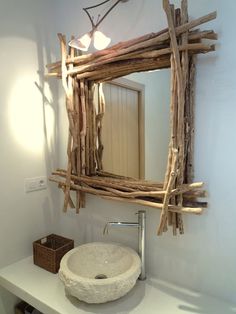 a bathroom sink made out of driftwood with a mirror above it and a basket on the counter