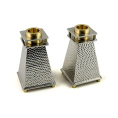 two metal salt and pepper shakers sitting on top of each other