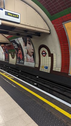 a subway station with an advertisement on the wall