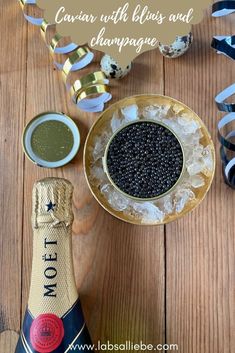 a bottle of cavia with blue and champagne next to it on a wooden table