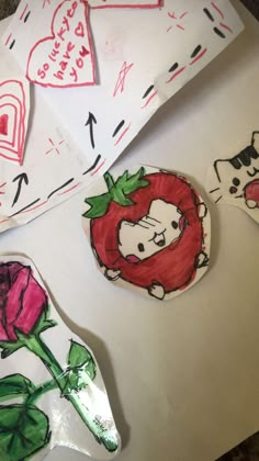 some paper plates with pictures of animals and flowers on them, one has a strawberry