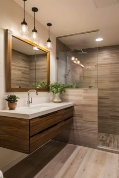 a bathroom with a sink, mirror and shower stall