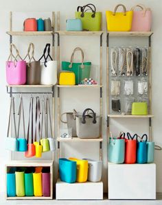 the shelves are filled with colorful bags and purses