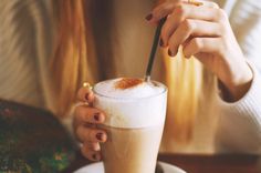 a woman is holding a drink in her hand