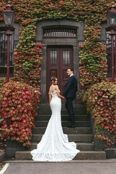 a bride and groom standing in front of an ivy covered building