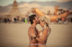 a man and woman kissing on the beach