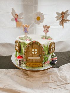 a cake decorated with fairy figurines and decorations