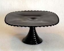 a black cake plate sitting on top of a white table