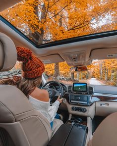 a woman sitting in the driver's seat of a car