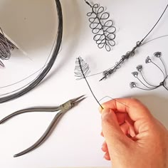 the person is working with wire and scissors on the table next to it are several other items