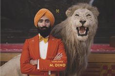 a man in an orange turban standing next to a lion