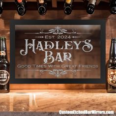 bottles of beer are lined up on a bar counter with a sign that says hadley's bar