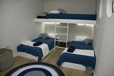 two bunk beds with blue and white sheets in a room