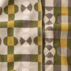 a close up view of a blanket with circles and squares on the fabric, as well as an open zipper