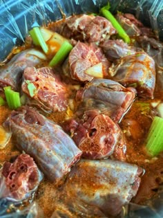 some meats and vegetables are in a bowl on top of plastic wrapper foil