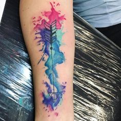 a watercolor tattoo with an arrow on the arm