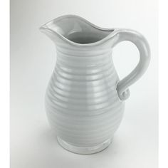 a white ceramic pitcher sitting on top of a table