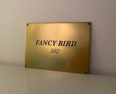 the fancy bird sign is mounted on the wall