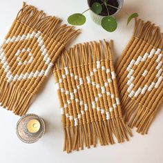 two pieces of woven material next to a potted plant on a white table top