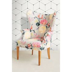 an upholstered floral chair against a geometric wall