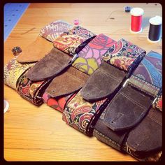 several different types of leather cases sitting on top of a wooden table