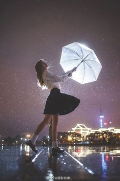 a woman holding an umbrella in the rain with buildings in the background