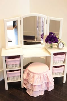 a white dressing table with mirror and stool