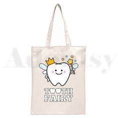 a tooth fairy tote bag with the words tooth fairy on it and a smiling tooth