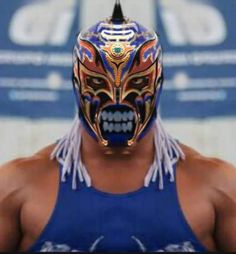 the wrestler is wearing a mask with feathers on it's head and his eyes are open