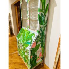 a green and white display case sitting on top of a hard wood floor next to a wall