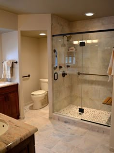 a large bathroom with a walk in shower next to a sink and toilet on the other side