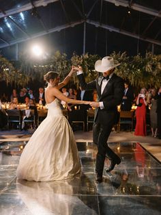 a bride and groom dance on the dance floor at their wedding reception in front of an audience