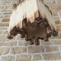 a wooden light hanging from the side of a brick wall