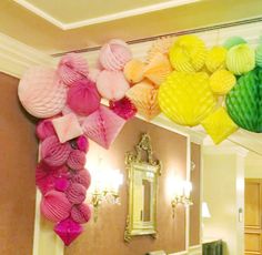 a bathroom decorated in pink, yellow and green with tissue lanterns hanging from the ceiling