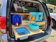 the back end of a van with various items in its cargo compartment, including bowls and plates